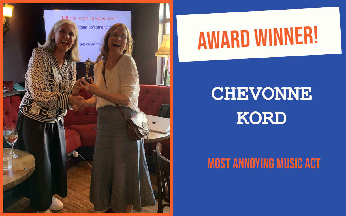 The winner of the July networking question at the Brighton networking meeting, holding the trophy with the meeting's host. Both people are laughing.