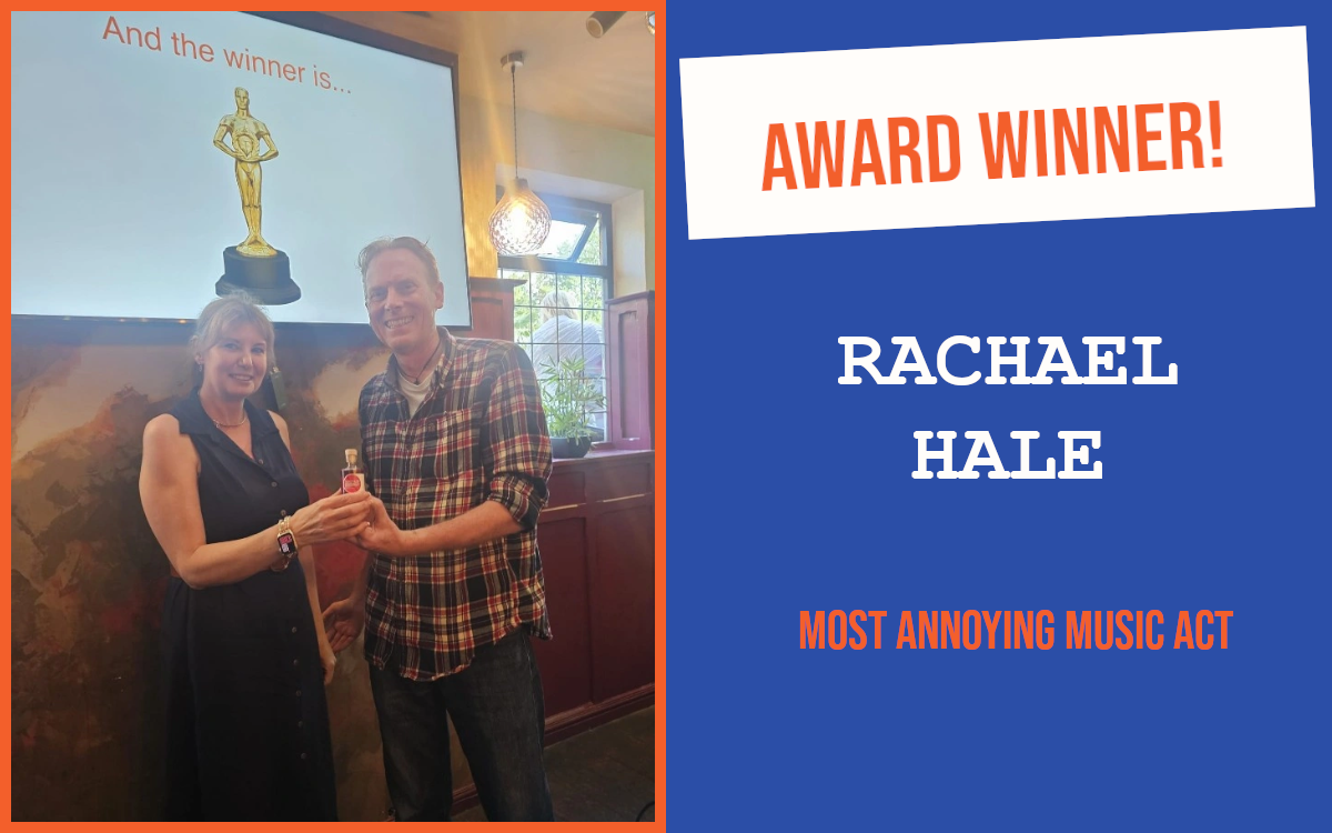 The winner of the networking question at the 3 rd Tunbridge Wells Pubnetworking event, holding a small bottle with the host, and standing in front of a large screen displaying a trophy.
