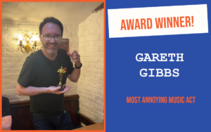The winner of the July networking question at the Norwich meeting of the Pubnetworking event, holding the trophy, smiling and making a gesture with their hand.
